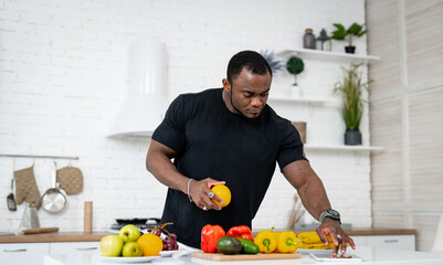 A Man Preparing a Healthy Meal in the Kitchen. A man in a kitchen cutting up vegetables