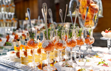 A Table Filled With a Variety of Delicious Food and Numerous Glasses. A table topped with lots of glasses filled with food