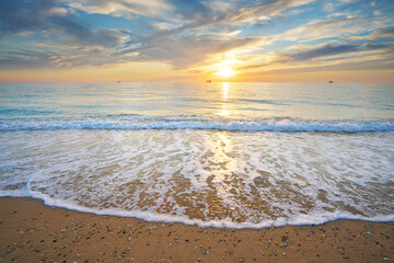 Sand and rocks on seashore at sunset. - 697183583