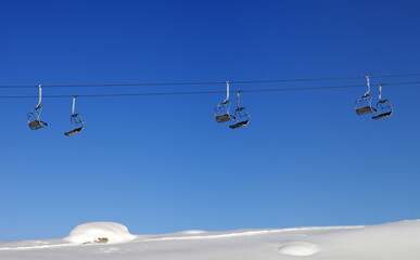 Chair-lift and blue clear sky at sun day