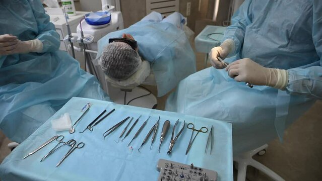 Dentist and assistant with Dental drill, syringe, dental mirror and other dental equipment before surgery wisdom tooth extraction in professional dental clinic. 4k raw cinematic slow motion video