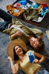 Happy couple traveler lying on floor cheering to buy tour with sale discount