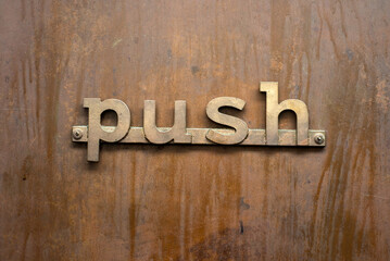 Closeup of push inscription on a rusty door of bar in the street 