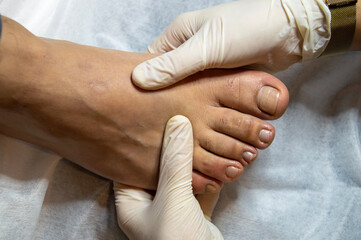 Girl in Beauty Salon doing pedicure to her male patient's toes