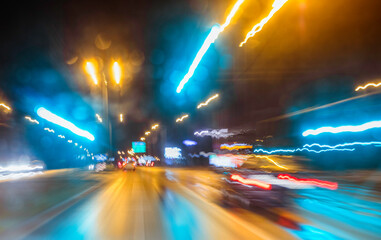 City colorful night lights perspective blurred by high speed of the car. A streak of light, trails.