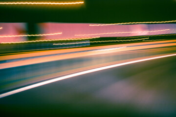 City colorful night lights perspective blurred by high speed of the car. A streak of light, trails.