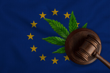 Flag of EU and justice wooden gavel with cannabis leaf. Illegal growth of cannabis plant and drugs...