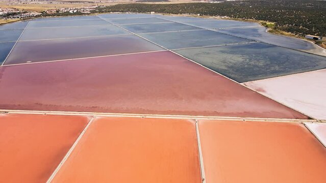 Aerial wide shot of extracting salt works from saltern pond or open salt evaporation ponds