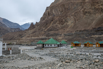 Under Construction houses in a valley with green nature and rocky hills in Ladakh, India. Ladakh's beautiful mountain landscape on the river shore.