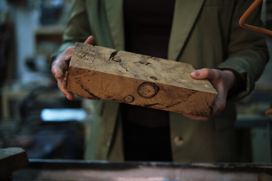 A woodworker s hands carefully assess a piece of burl, where the swirls and knots speak of the wood s journey from nature to craft. - Powered by Adobe