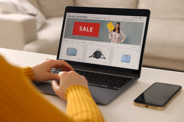 Woman shopping online during sale on laptop at home, closeup