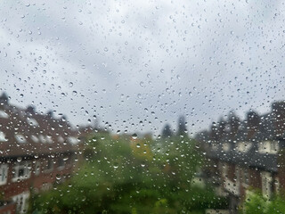View on city street through window with water droplets on rainy day, closeup
