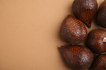 Delicious salak fruits on pale brown background, above view. Space for text