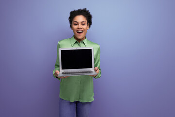successful young cute latin woman dressed in green blouse shows laptop screen with mockup