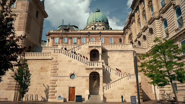 Budapest, Hungary . People are going up in to the castle courtyard in Buda. The large green dome stands out. Beautiful summer day.