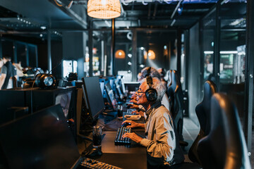 Senior man playing computer game in gaming lounge during weekend