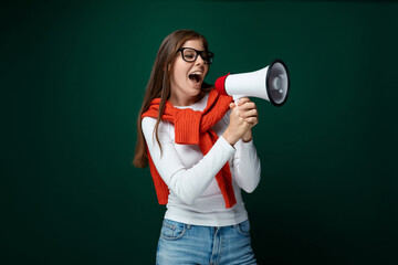 European young woman in a white turtleneck shouts news and promotions into a megaphone