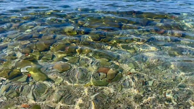 Mieniąca się woda morska i kamienisty brzeg