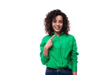 young bright smiling european brunette woman with curly styling in a green shirt works in an...