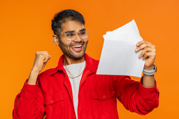 Indian man open envelope take out letter reads it feel happy. Career growth advance promotion, bank...