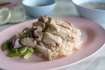 Boiled chicken, offal with cucumber sliced eating with rice and spicy or sweet sauce.