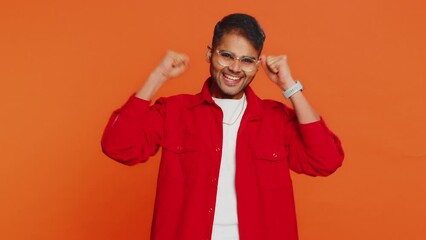 Countdown to holiday birthday celebration victory win. Indian man counting in reverse order from five to one. Arabian young guy isolated on orange background indoors. Happy New Year Merry Christmas