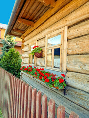 Fototapeta na wymiar fragment wooden house built in traditional style with flowers. Poland