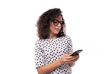 young caucasian woman with curly hair styling writes a message in the phone