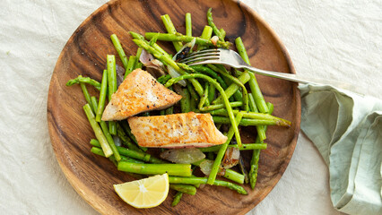 fried tuna fillet with asparagus on a wooden plate