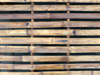 Fragment of an old bamboo wall as a background or texture. Structure of an old bamboo wall. Texture background of old bamboo wall