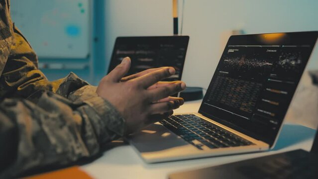 Intelligence officer typing on laptop, controlling missions, gathering intel