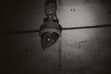 A broken lamp hangs in an abandoned building. Light and shadow. Shabby walls.