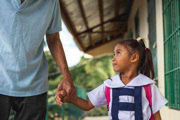 A young girl looks fondly at her grandfather, who picks her up from school. At a provincial primary...