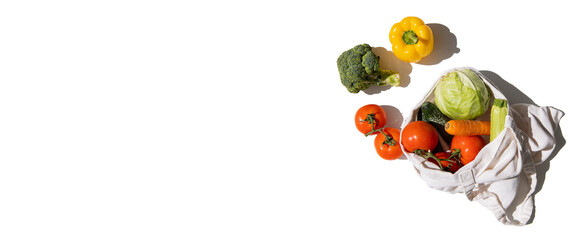 Fresh vegetables in a cloth bag on a white background. Top view, flat lay. Banner