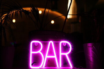 Neon bar sign on dark background. Night club concept. Copy space