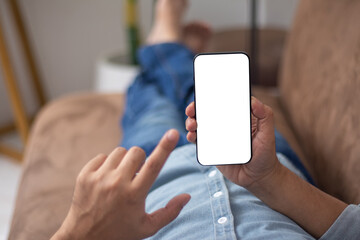 Man lying on the sofa playing with his phone