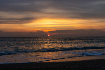 Fototapeta premium Imagine waking up to the gentle sound of the waves lapping against the shore, the cool sea breeze caressing your face and the first rays of the sun painting the sky in shades of pink, orange and gold.