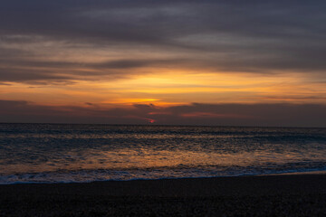 Fototapeta premium Imagine waking up to the gentle sound of the waves lapping against the shore, the cool sea breeze caressing your face and the first rays of the sun painting the sky in shades of pink, orange and gold.
