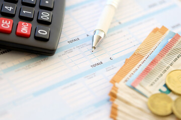 Filling italian tax form process with pen, calculator and euro money bills close up. Tax paying...