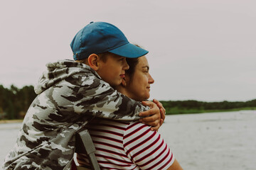Lakeside Family Affection: Son Tenderly Embracing Mother on Camping Getaway