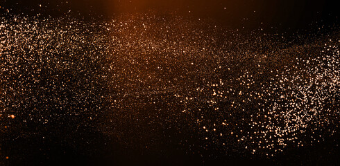 Gold colored cloud stardust glitter with light, bokeh in air on black background for overlay...