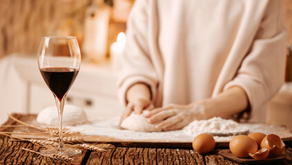 Glass of red wine on wooden table with ears of wheat and eggshells against the background of a...