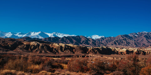 Picturesque panorama with snowy high mountains in autumn