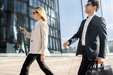 Business young people managers, male and female partners go to the office to work, colleagues in business clothes, positive employees.