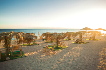 Sun umbrellas and sunbeds on sandy beach. Travel and holiday concept