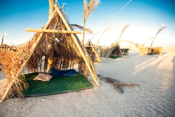 Zelfklevend Fotobehang Wooden huts on sand beach landscape in clear blue sky. Vacation and travel concept © Aleksej