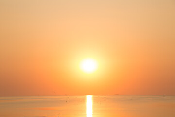 Beautiful sunset near the shore on the sea, background with sunset, orange sunset