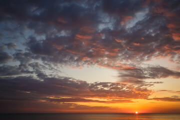 Naklejka na ściany i meble Beautiful sunset near the shore on the sea, background with sunset, orange sunset