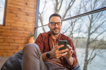 One adult man at home use smart phone app browse internet or send sms