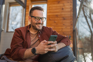 One adult man at home use smart phone app browse internet or send sms
